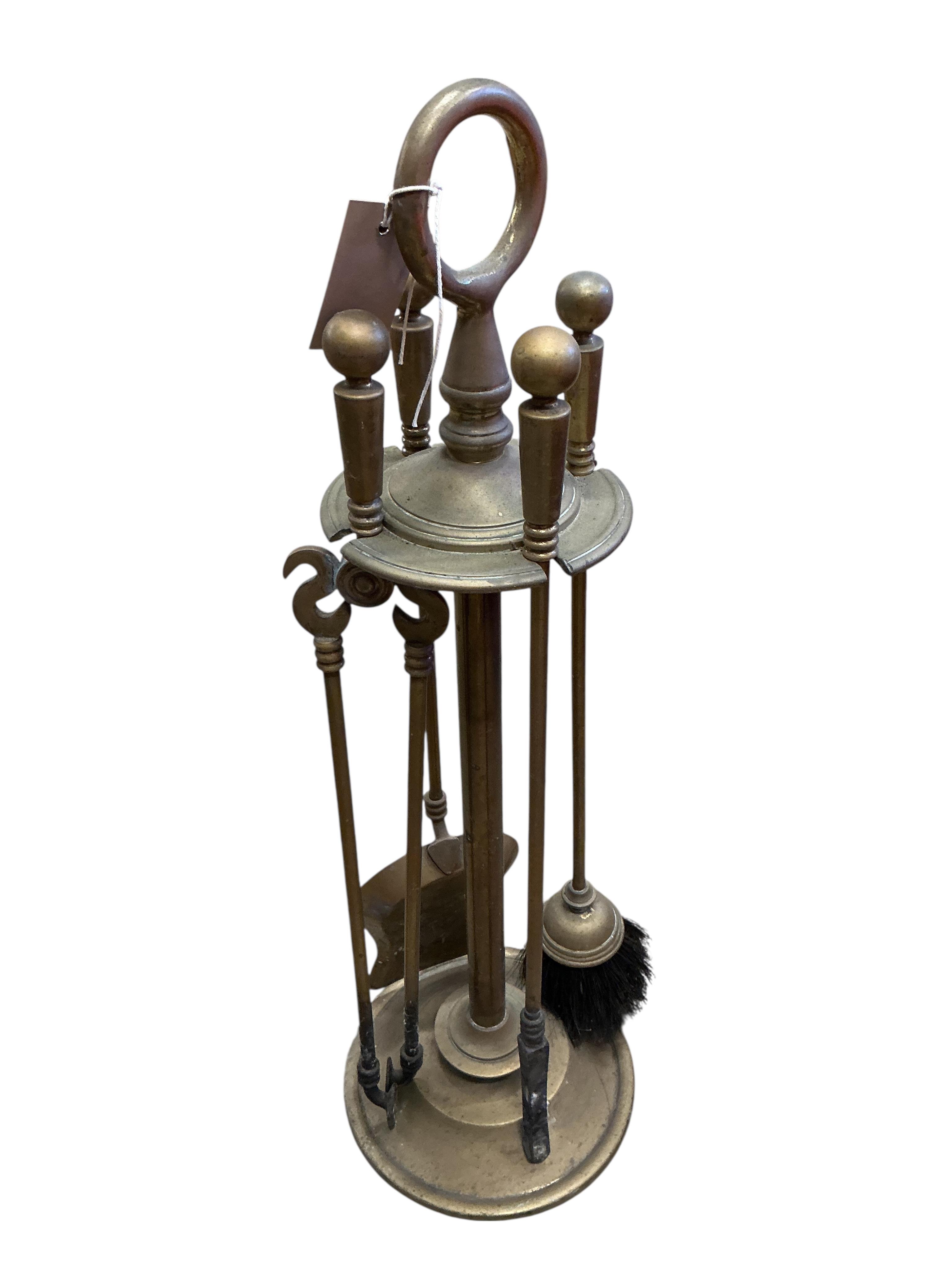 A brass four piece fire implement set, height 65cm